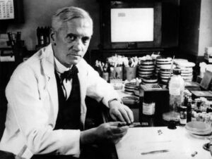 Black and white photograph of Alexander Fleming working in a lab.