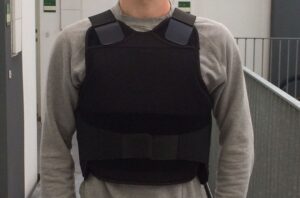 A man wearing a black bullet and stab proof vest.