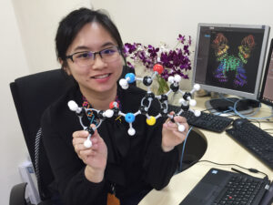 Woman holding a molecular model.